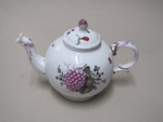 Teekanne mit Früchten und Blumen