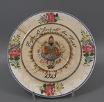 Großer Teller mit Wächtersbacher Rose, Mädchen in Schwälmer Tracht und Umschrift: "Besser "K." Brot als "kaa" Brot!" 1915